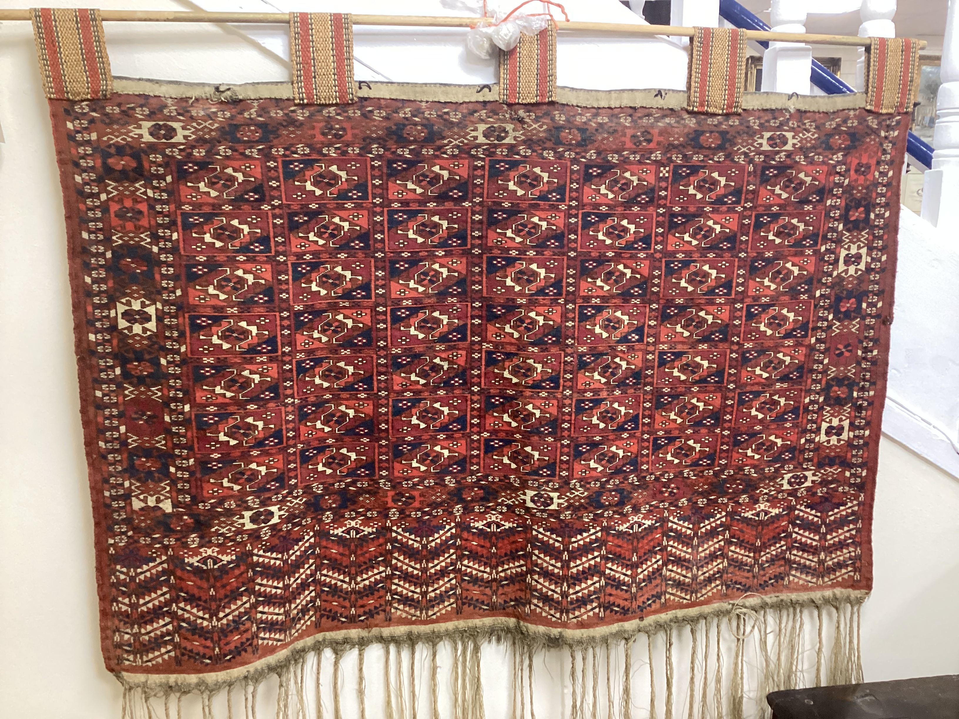 An antique Tekke Turkoman wall hanging, width 110cm, height excluding fringe 82cm